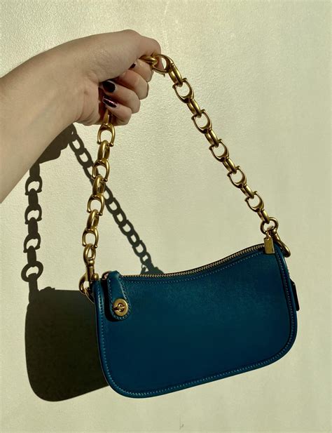 coach handbag with chain strap.